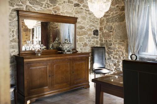 een kamer met een spiegel en een houten dressoir bij O Rincón de Mercedes in Jove