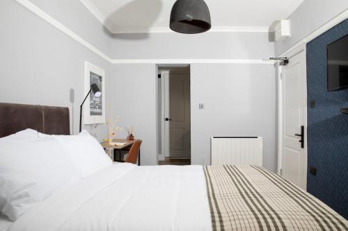 a bedroom with a white bed and a tv at Bob W London Paddington in London