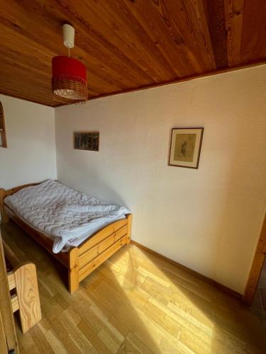 a bedroom with a bed in a room with a wooden ceiling at Ferienhaus am Steinmeister Turm in Naumburg