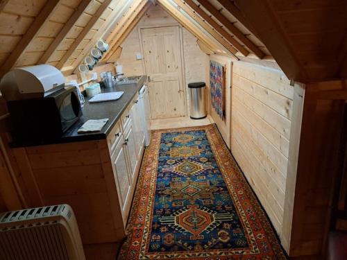 an inside view of a kitchen with a rug on the floor at Antler Lodge in Rushton Spencer