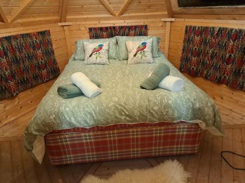 a bedroom with a bed with two birds on it at Antler Lodge in Rushton Spencer