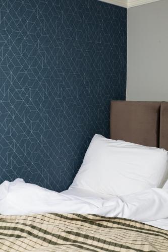 a bedroom with a bed with a blue wall at Bob W London Paddington in London