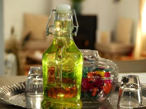 a green bottle on top of a table with glasses at Aretousa by PosarelliVillas in Dhrakóna