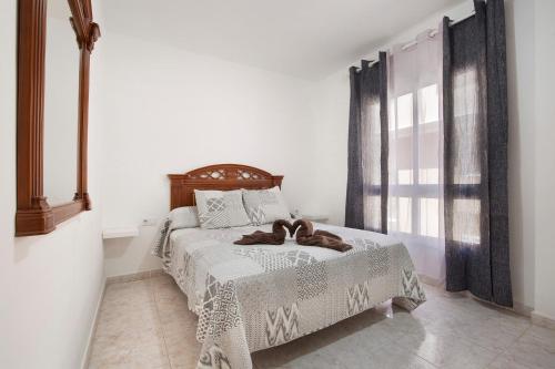 a bedroom with a bed with a brown bow on it at Casa Rosi in Gran Tarajal