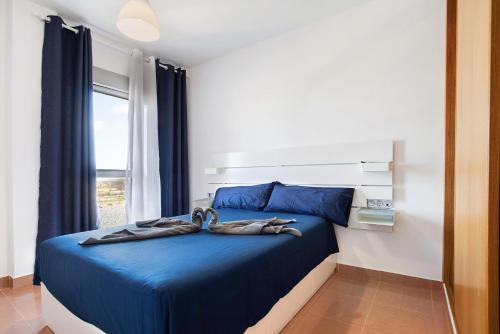 Un dormitorio con una cama azul con toallas. en Casa Rosi 2, en Puerto del Rosario