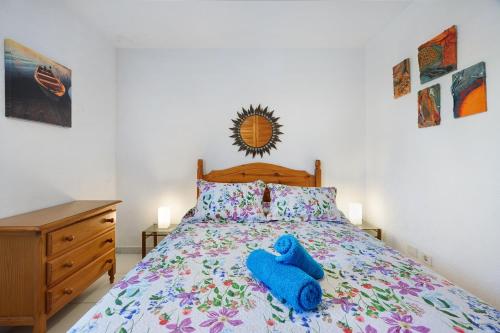 a bedroom with a bed with a blue stuffed animal on it at Bungamerica272 in Playa de las Americas