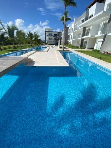 ein großer blauer Pool neben einem Gebäude in der Unterkunft Estancia Mónaco, Hard Rock CANA BAY in Punta Cana