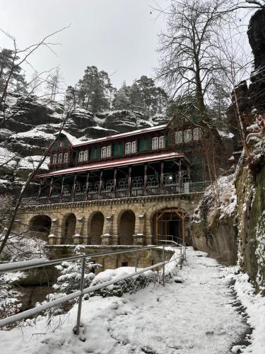 a large building with snow on the ground at U Vaclava in Hřensko