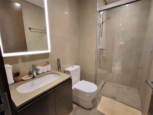 a bathroom with a shower and a toilet and a sink at Perfect 1 BR for Family Stay - Close to Downtown in Dubai