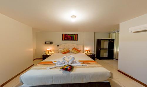 Un dormitorio con una cama grande con una flor. en ANDINO HOTEL MACHUPICCHu, en Machu Picchu