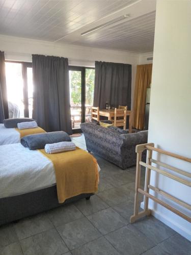 ein Wohnzimmer mit 2 Betten und einem Sofa in der Unterkunft Bee Comfy in Klein-Brakrivier
