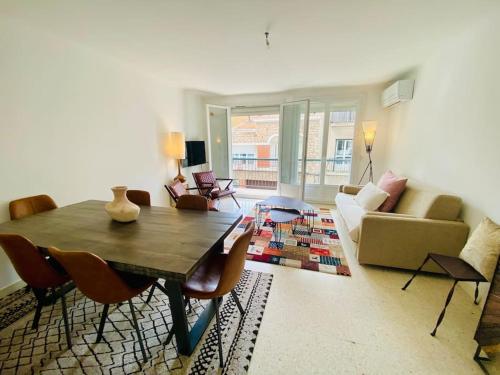 un salon avec une table et des chaises en bois dans l'établissement ''Clavel 14'' Charmant T3 en ville avec clim et parking, à Sète