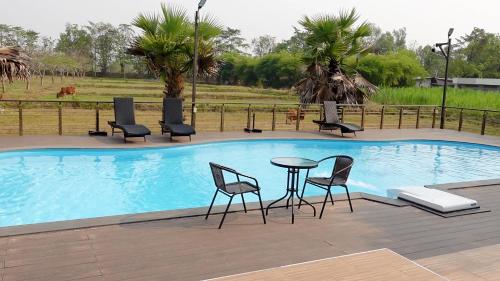 - une piscine avec des chaises et une table en face dans l'établissement Khwaithai Resort & Homestay - ควายไทย, 