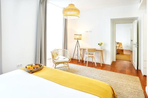 a bedroom with a bed and a living room with a table at Beach Waves Apartment in Faro