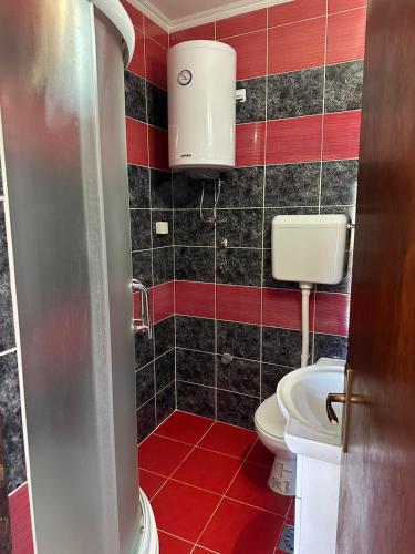 a small bathroom with a toilet and red tiles at Apartman Zaga in Trebinje
