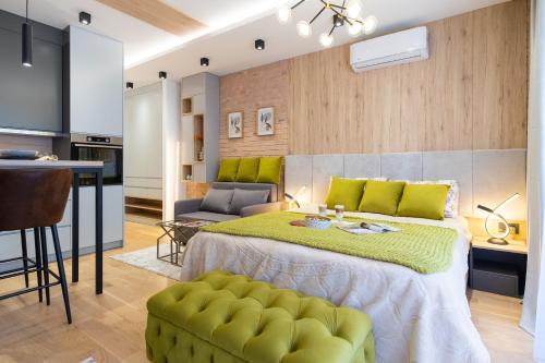 a bedroom with a large bed with green pillows at Urban Studio Apartman in Trebinje