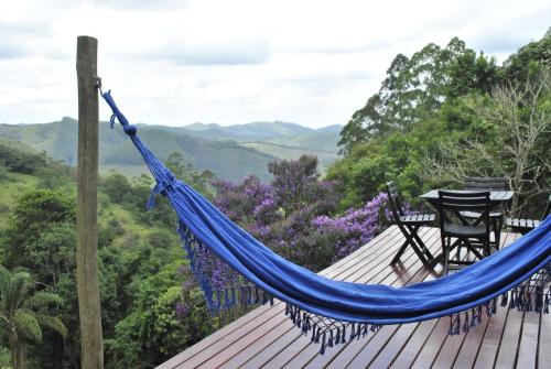 een hangmat op een terras met uitzicht op de bergen bij Tao da Serra - cabana em meio à natureza! in São Francisco Xavier