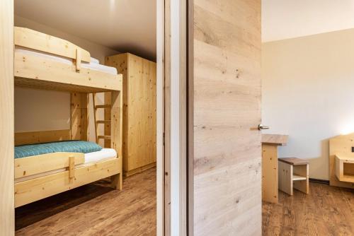 Zimmer mit 2 Etagenbetten und einem Schrank in der Unterkunft Villa Lara Fichte in Kastelruth