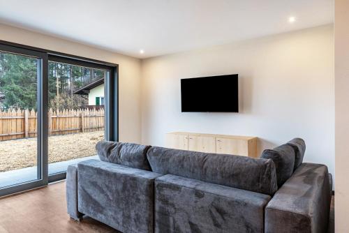 - un salon avec un grand canapé et une télévision à écran plat dans l'établissement Villa Lara Fichte, à Castelrotto