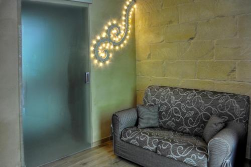 a living room with a couch and a brick wall at Baia Dei Micenei in Otranto