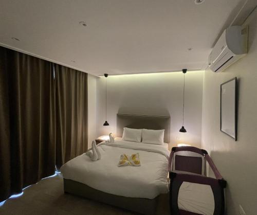 a hotel room with a bed with a bow on it at Zerø Føur DeadSea in Sowayma