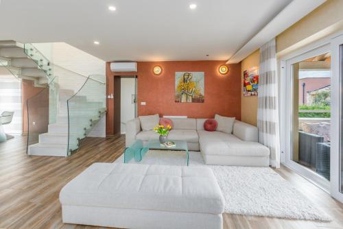 un soggiorno con un divano bianco e un tavolo di Villa Anabel with pool a Kaštelir (Castellier)