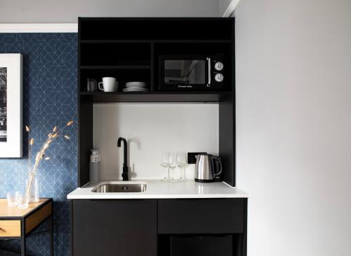 a kitchen with a sink and a microwave at Bob W London Paddington in London