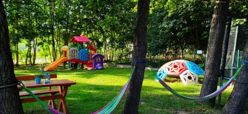 a playground with a swing set and a table in a park at Domki latonafali in Dąbki