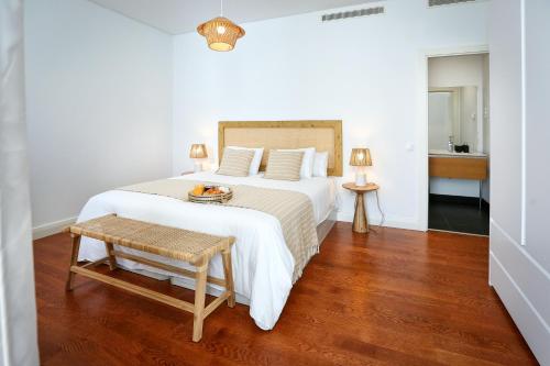 a bedroom with a large white bed with a wooden floor at Algarve Sweetness Apartment in Faro