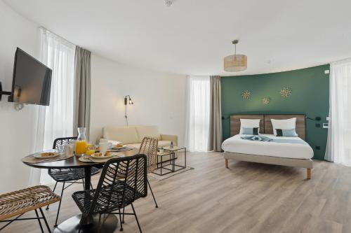 sypialnia z łóżkiem i stołem z jadalnią w obiekcie All Suites Noisy Le Grand w mieście Noisy-le-Grand