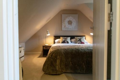 ein Schlafzimmer mit einem großen Bett im Dachgeschoss in der Unterkunft Hertford Barn conversion in Hertford