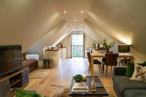 an attic living room with a couch and a table at Hertford Barn conversion in Hertford