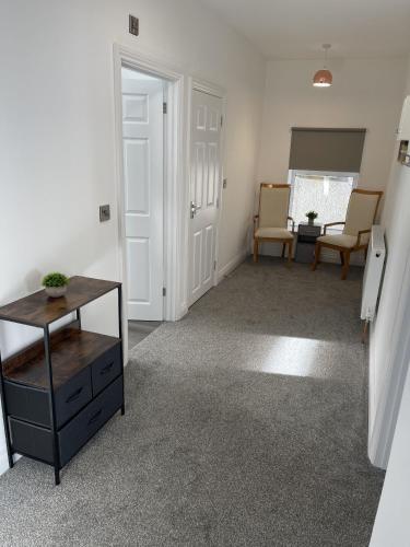 una sala de estar vacía con mesa y sillas en Englehurst Mews flat 2, en Buxton