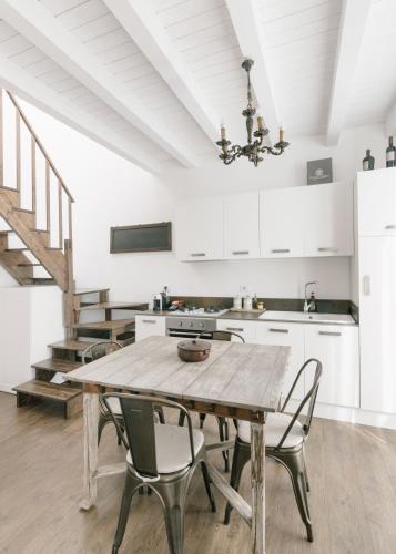 a kitchen with a wooden table and chairs at Addimora Boutique Suites in Palermo