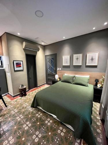 um quarto com uma grande cama verde num quarto em Lola’s home em Assunção