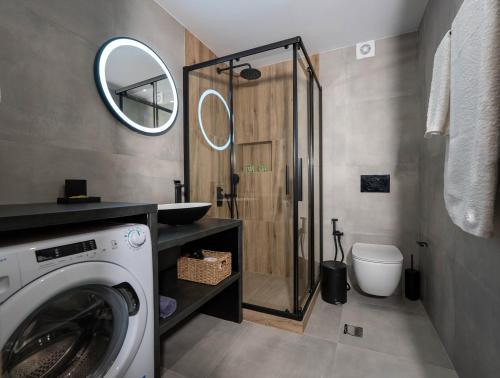 a bathroom with a washing machine and a shower at Central Suites Aegina 1 in Aegina Town
