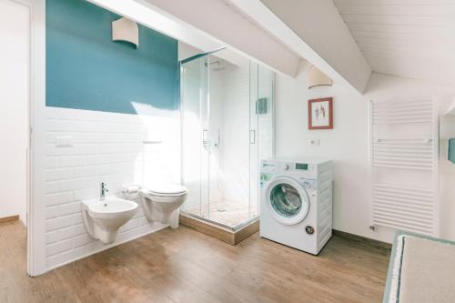 a bathroom with a toilet sink and a washing machine at Addimora Boutique Suites in Palermo