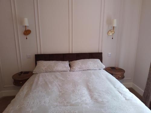 a bedroom with a white bed with two end tables at Linroy Guest House in Skegness