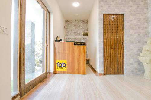 una puerta pivotante en el medio de una habitación en FabHotel Sky Lark Farm, en Ludhiana