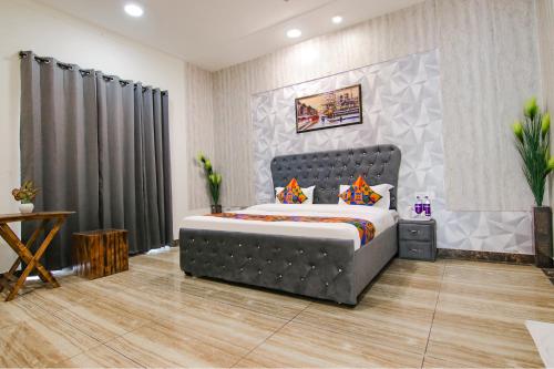 Un dormitorio con una cama grande en una habitación. en FabHotel Sky Lark Farm, en Ludhiana