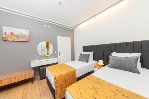 Habitación de hotel con 2 camas y espejo en Continent Hotel Kapadokus Thermal en Guzelyurt