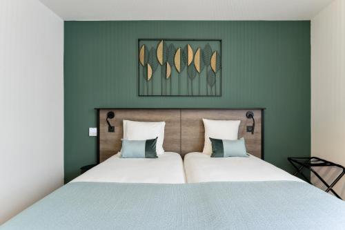 Ένα ή περισσότερα κρεβάτια σε δωμάτιο στο All Suites Appart Hôtel - Noisy-le-Grand