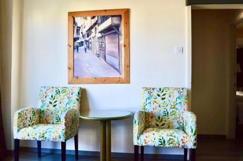 two chairs and a table in a room with a mirror at Lordos Hotel Apartments Nicosia in Nicosia