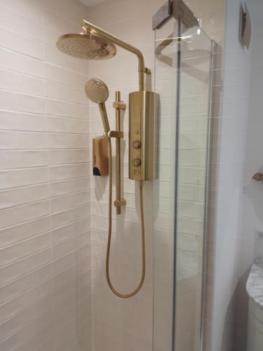 a shower with a shower head in a bathroom at Linroy Guest House in Skegness
