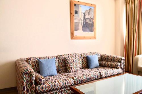 a living room with a couch with blue pillows at Lordos Hotel Apartments Nicosia in Nicosia
