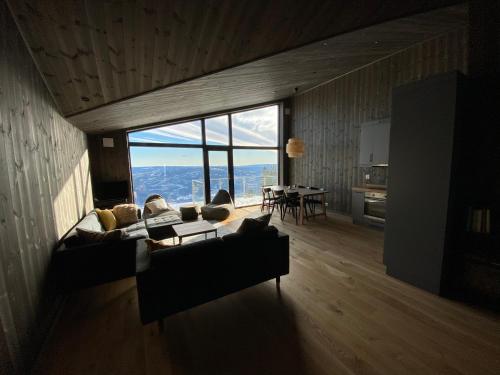a living room with a couch and a large window at Cosy apartment with ski in/out in Noresund