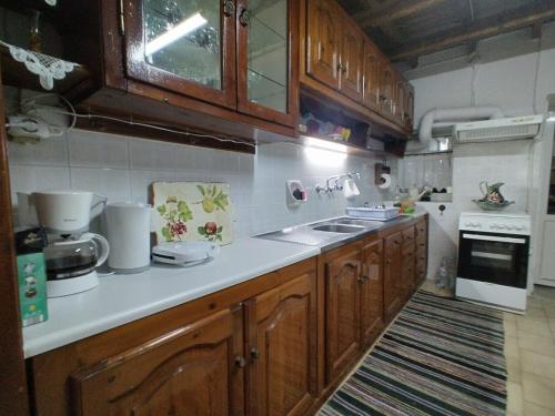 cocina con armarios de madera y encimera blanca en Vaggelitsa's House, en Pythagoreio