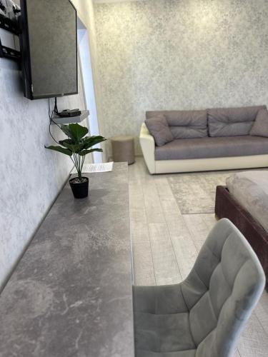 a living room with a couch and a chair at Новая современная квартира в центре города in Kostanay
