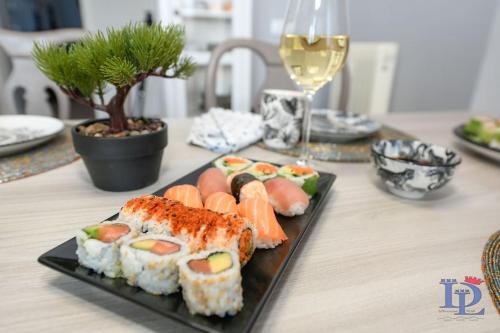 un plato de sushi en una mesa con una copa de vino en DesenzanoLoft Smiling in Desenzano, en Desenzano del Garda