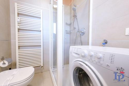 a white washing machine in a bathroom with a toilet at DesenzanoLoft Smiling in Desenzano in Desenzano del Garda